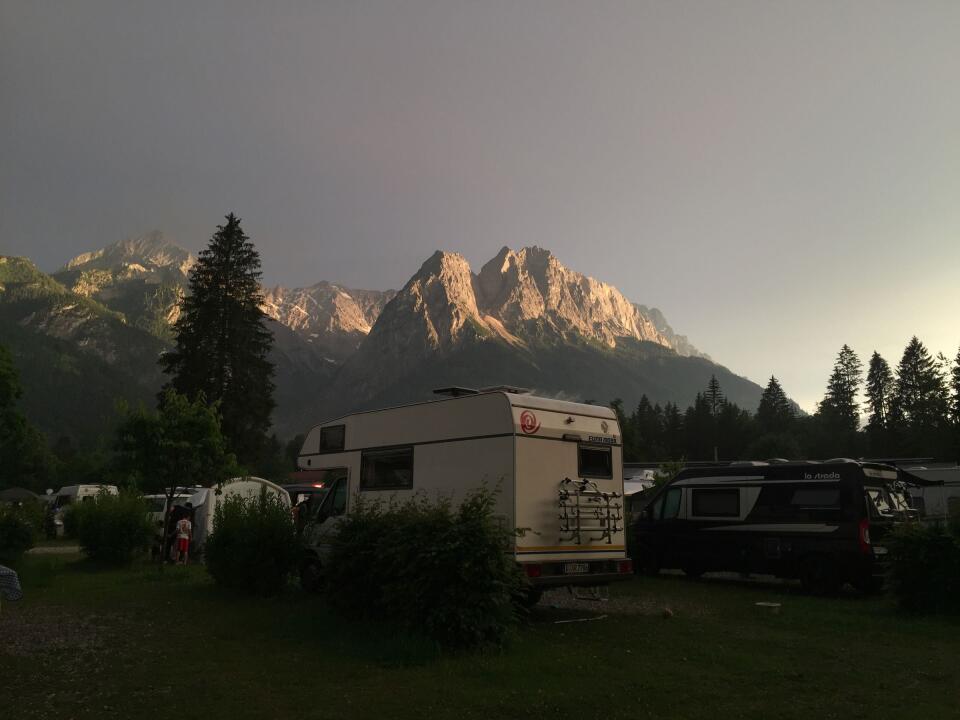 Our camper in dramatic light in front of a mountain range.