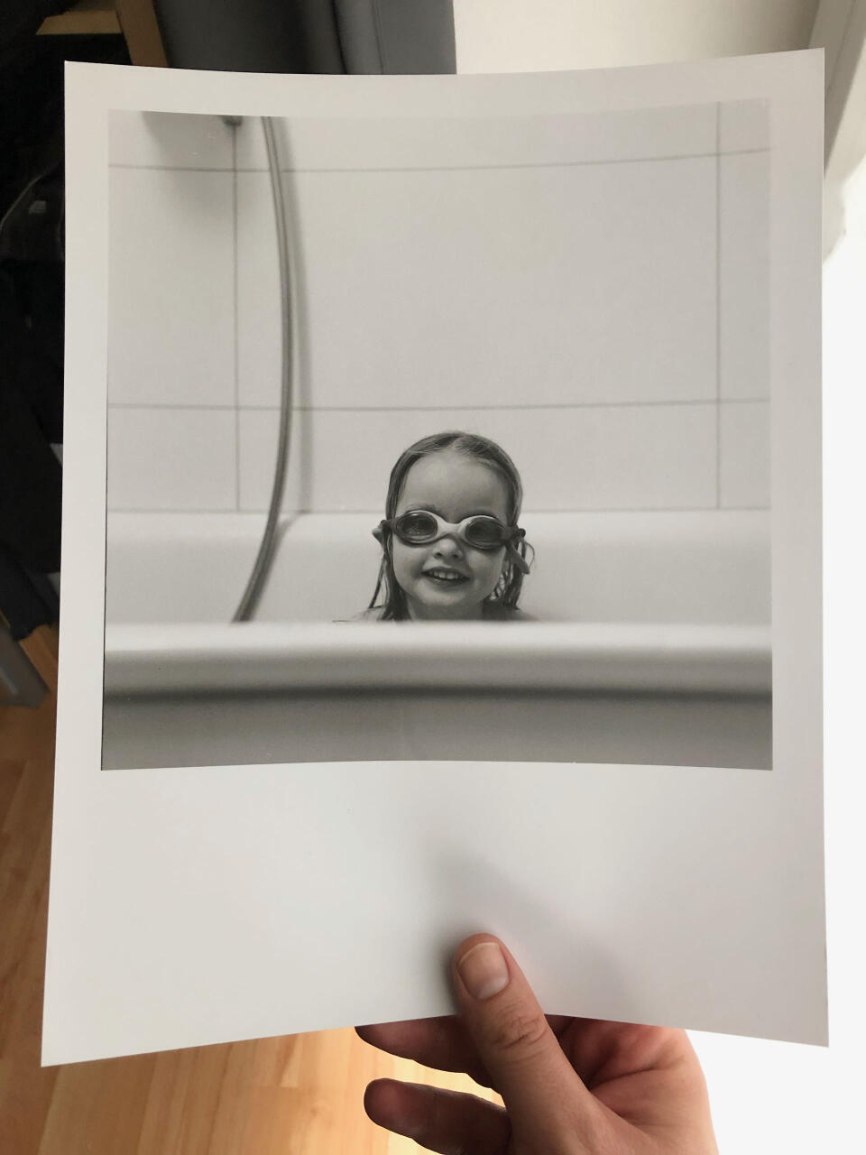 Zoe (3) in the bathtub, with swimming goggles on.