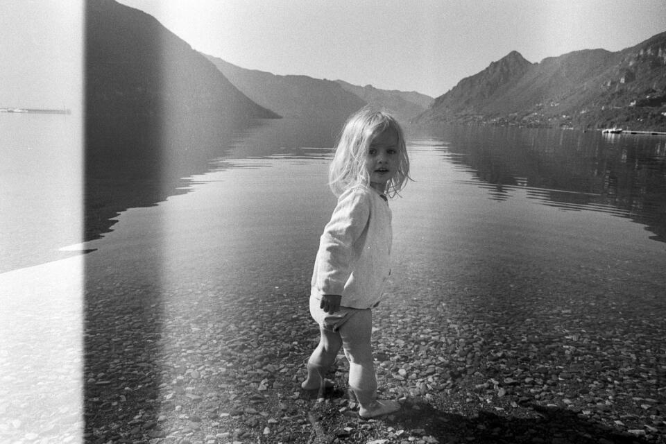 Zoe knee-deep in a lake, looking back at the camera.