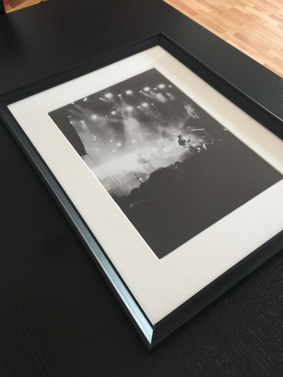 A large framed print of a live concert.