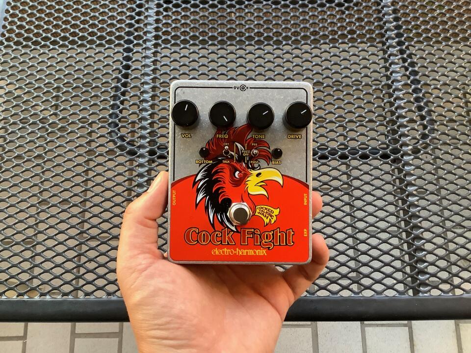 Holding the EHX Cock Fight guitar pedal in my hand.