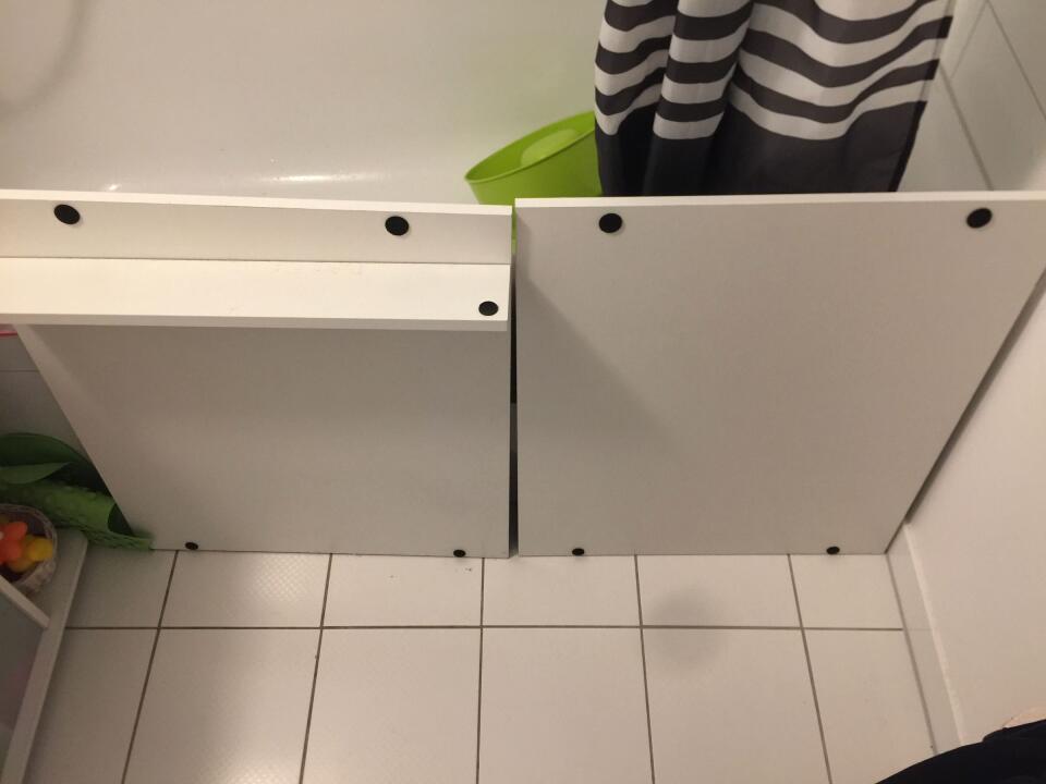 Two shelf boards leaning against the side of a bathtub