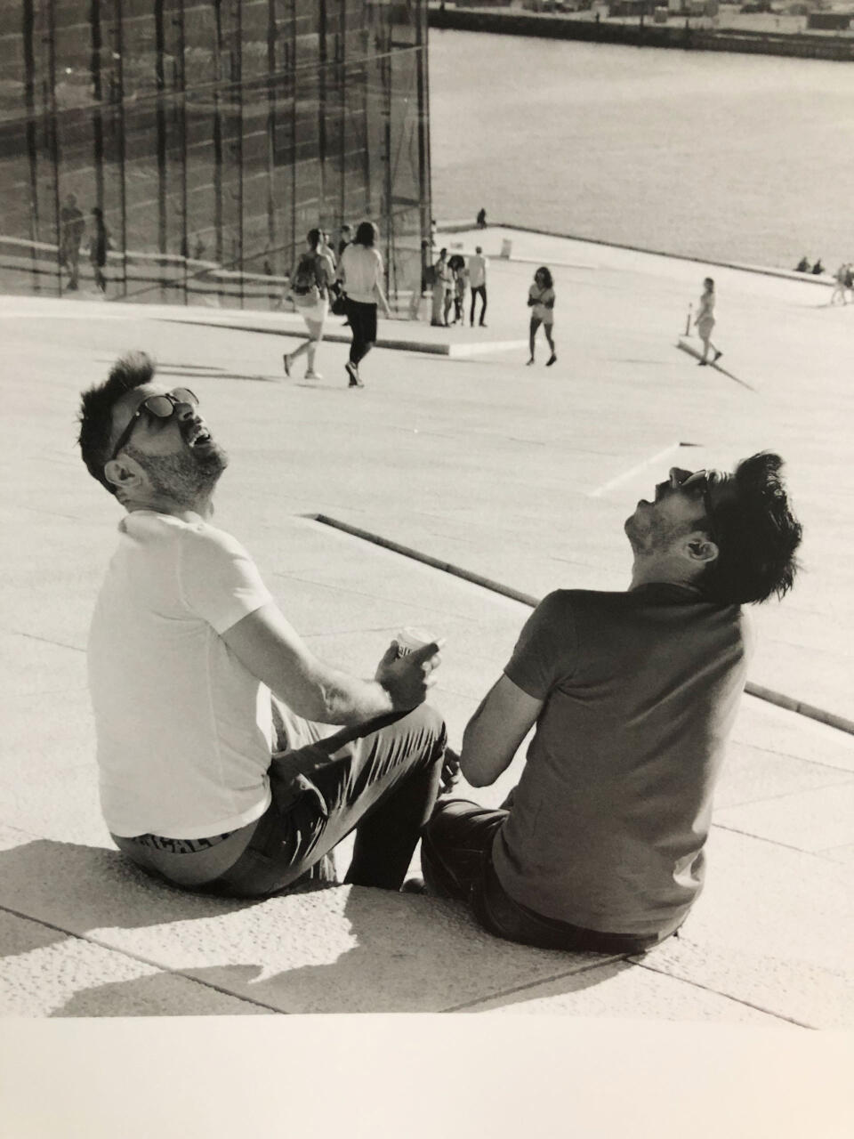 A detail/crop of two very similar looking men, sitting on the 